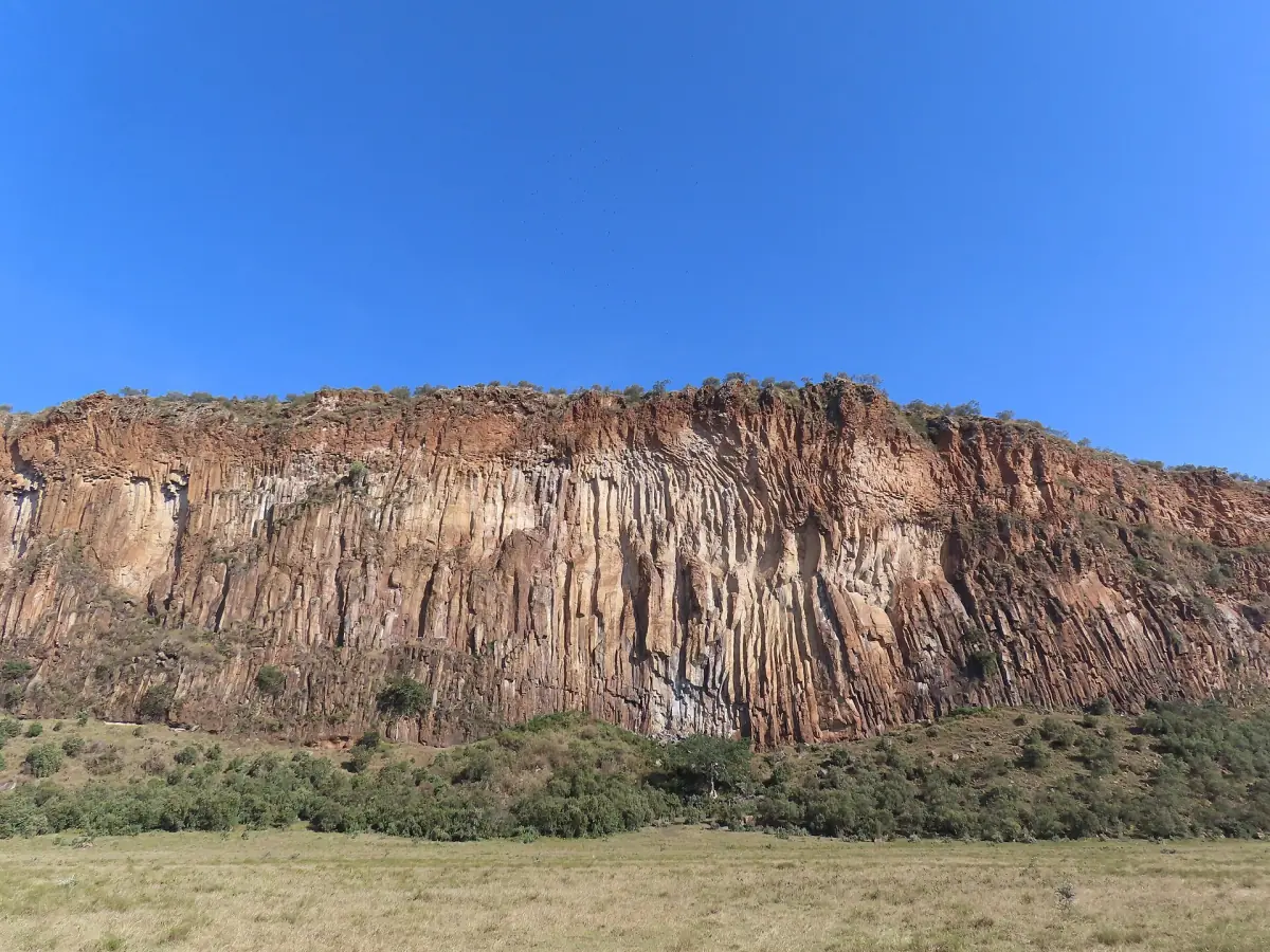 Tall cliff of volcanic rock columns above the plain in Hell's Gate