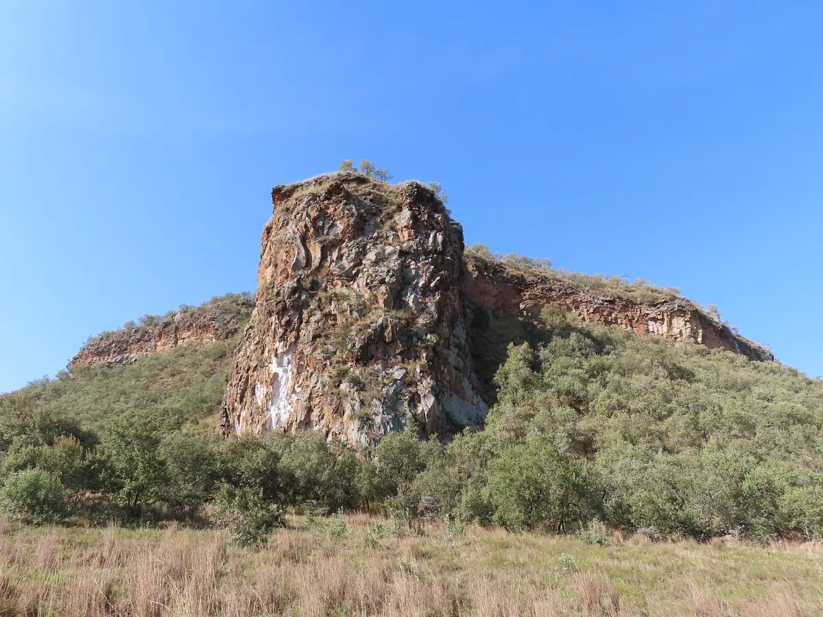 Fischer's Tower op een rotsachtige heuvelhelling onder een heldere blauwe lucht in Kenia