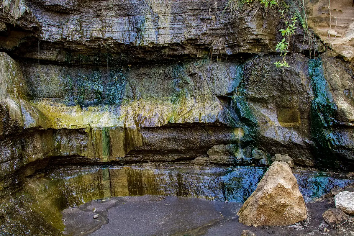 Gorge wall with green mineral stains above a small pool in Hell's Gate