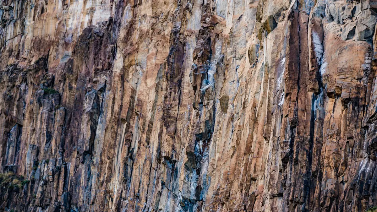 Vertical orange rock face with dark streaks, a typical climbing wall in Hell's Gate